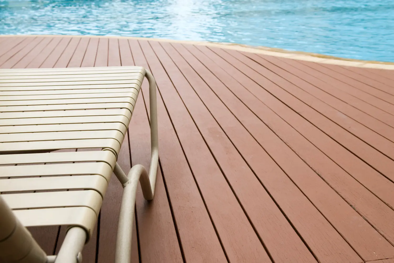 Close-up of freshly painted pool deck with a chair, showcasing expert refinishing work in Savannah.