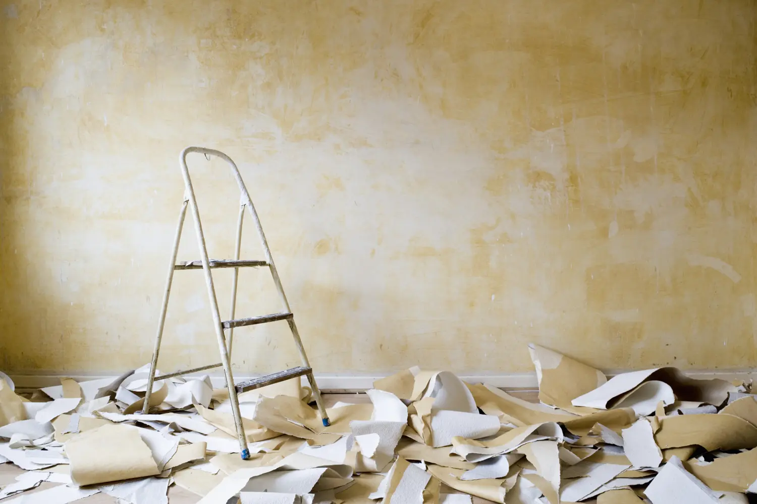 Detailed view of wallpaper being removed with a scraper, Savannah painting contractor at work.